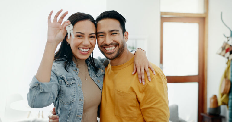 New home keys, hug and portrait of happy couple moving into house, real estate property or apartment purchase. Love, homeowner smile and Mexican man, woman or relocation people embrace in living room