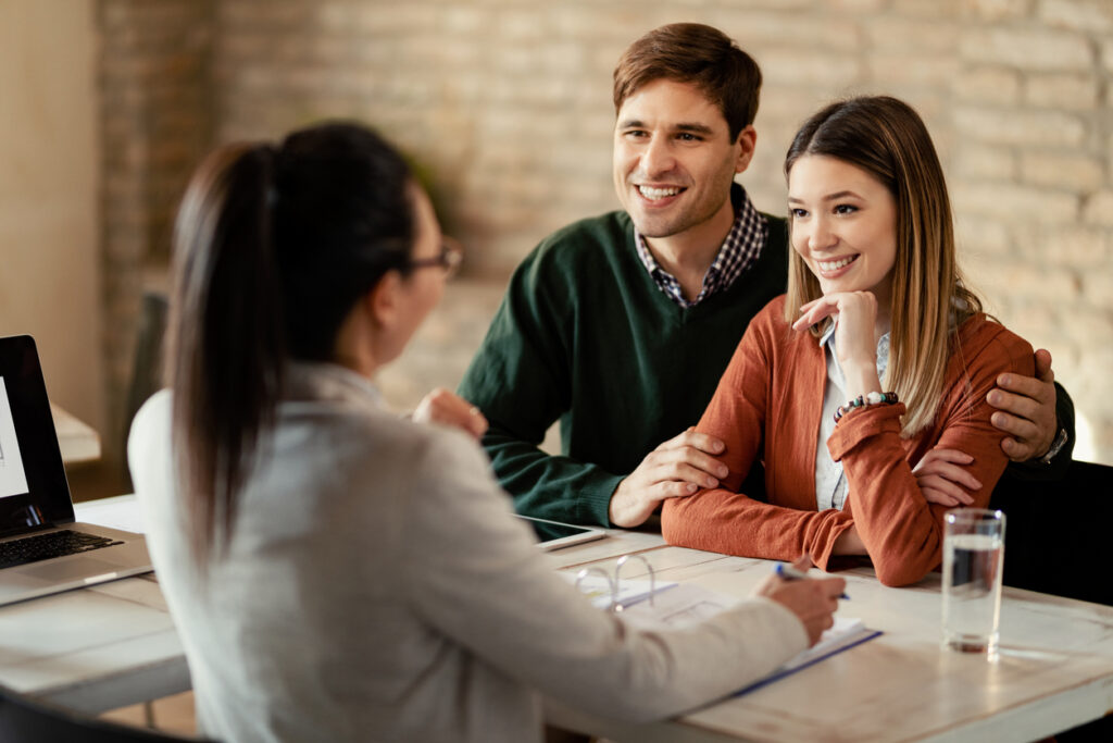 Young happy couple talking to financial advisor during a meeting in the office.